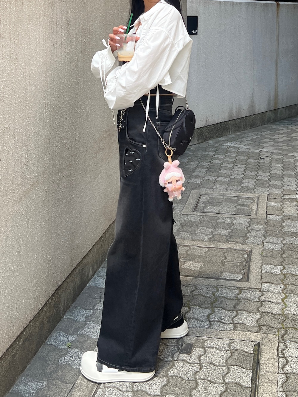 ホワイト系のシャツ/ブラウス、ブラック系のデニムパンツ、ブラック系のハンドバッグを着用したレディースの夏コーディネートの2枚目の写真