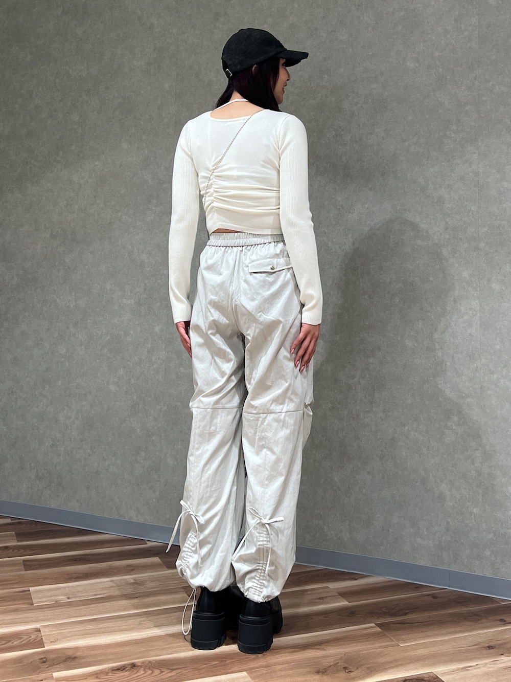 ホワイト系のニット/セーター、ホワイト系のその他パンツ、ブラック系のハンドバッグを着用したレディースの冬コーディネートの4枚目の写真