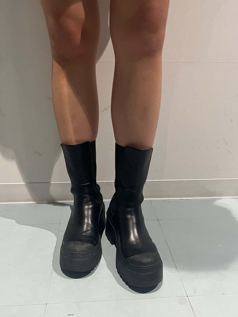 グリーン系のブルゾン、ブラック系のスカート、ブラック系のブーツを着用したレディースの秋コーディネートの6枚目の写真