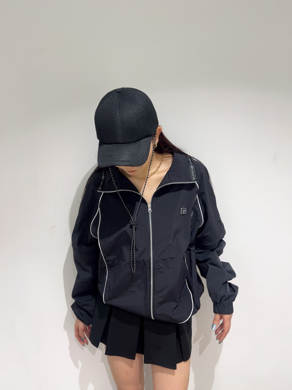 ブラック系のブルゾン、ブラック系のスカート、ブラック系のブーツを着用したレディースの春コーディネートの7枚目の写真