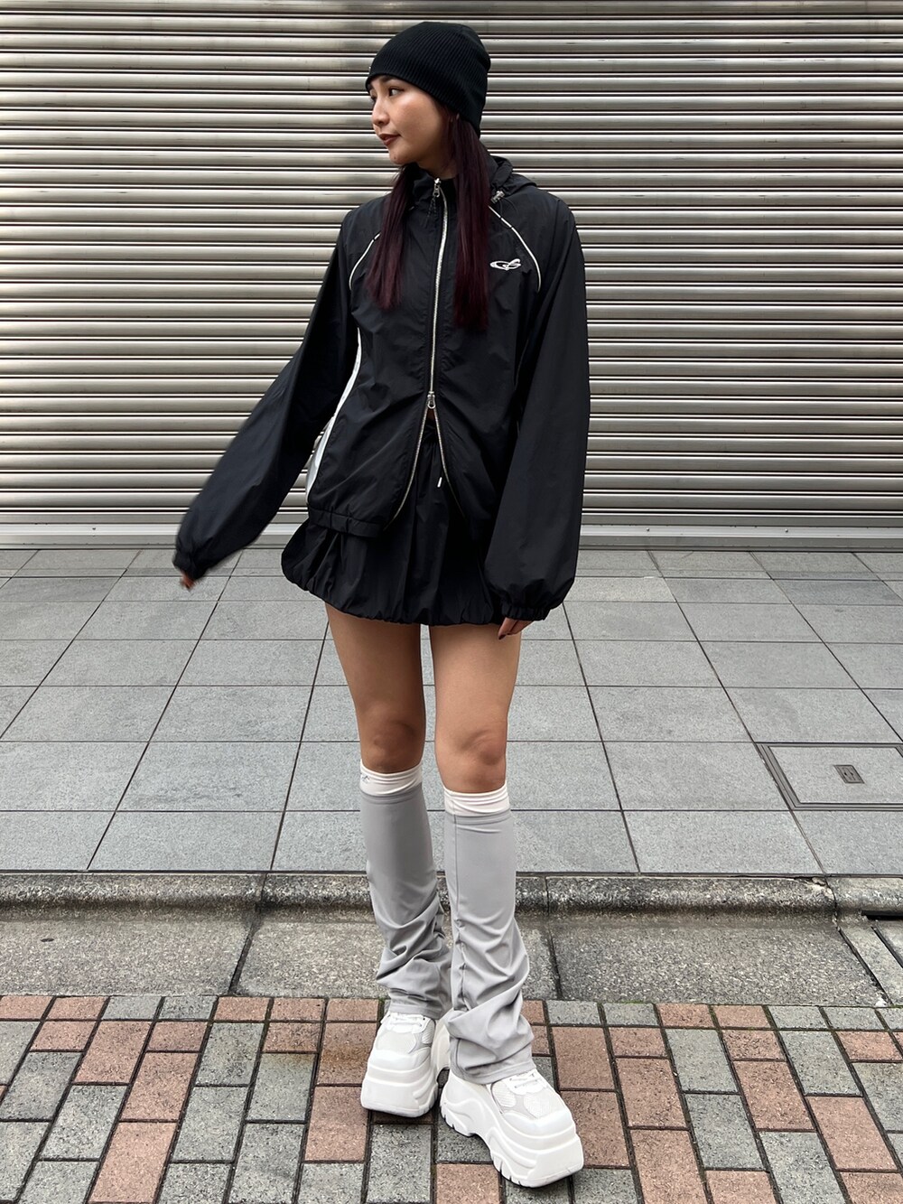 ブラック系のブルゾン、ブラック系のスカート、ホワイト系のスニーカーを着用したレディースの冬コーディネートの2枚目の写真