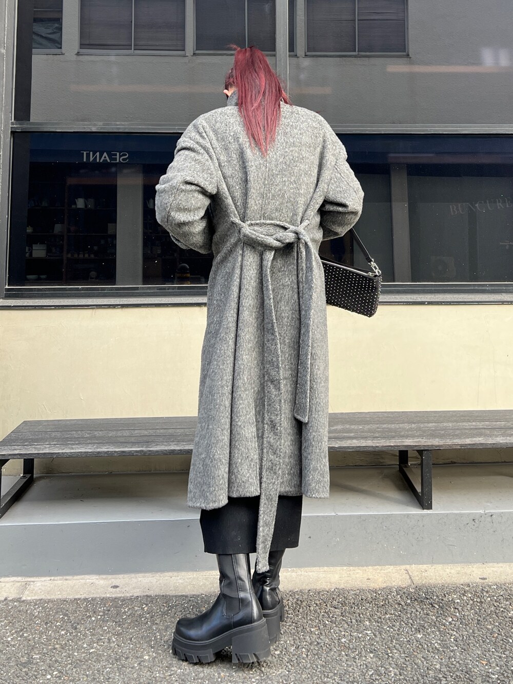 ブラック系のニット/セーター、ブラック系のワンピース、グレー系のその他アウターを着用したレディースの冬コーディネートの5枚目の写真