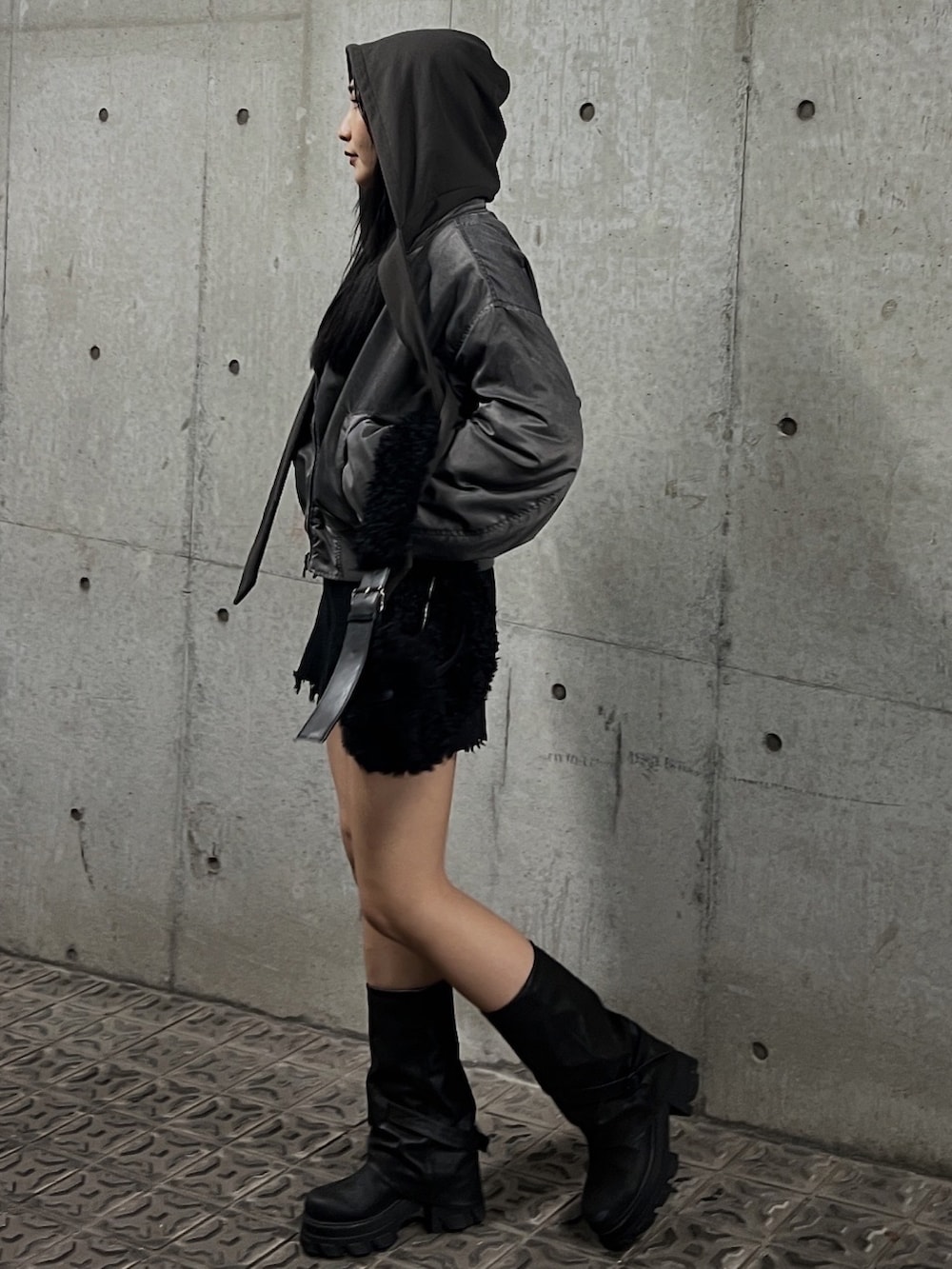 グレー系のブルゾン、グレー系のTシャツ/カットソー、ブラック系のブーツを着用したレディースの秋コーディネートの2枚目の写真