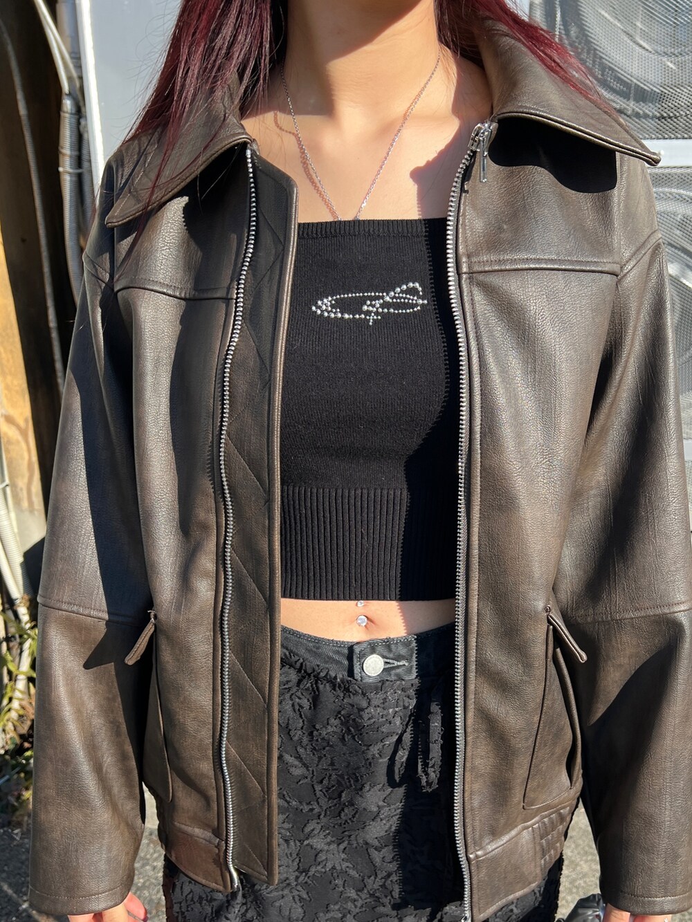 ブラウン系のブルゾン、ブラック系のニット/セーター、ブラック系のスカートを着用したレディースの冬コーディネートの5枚目の写真