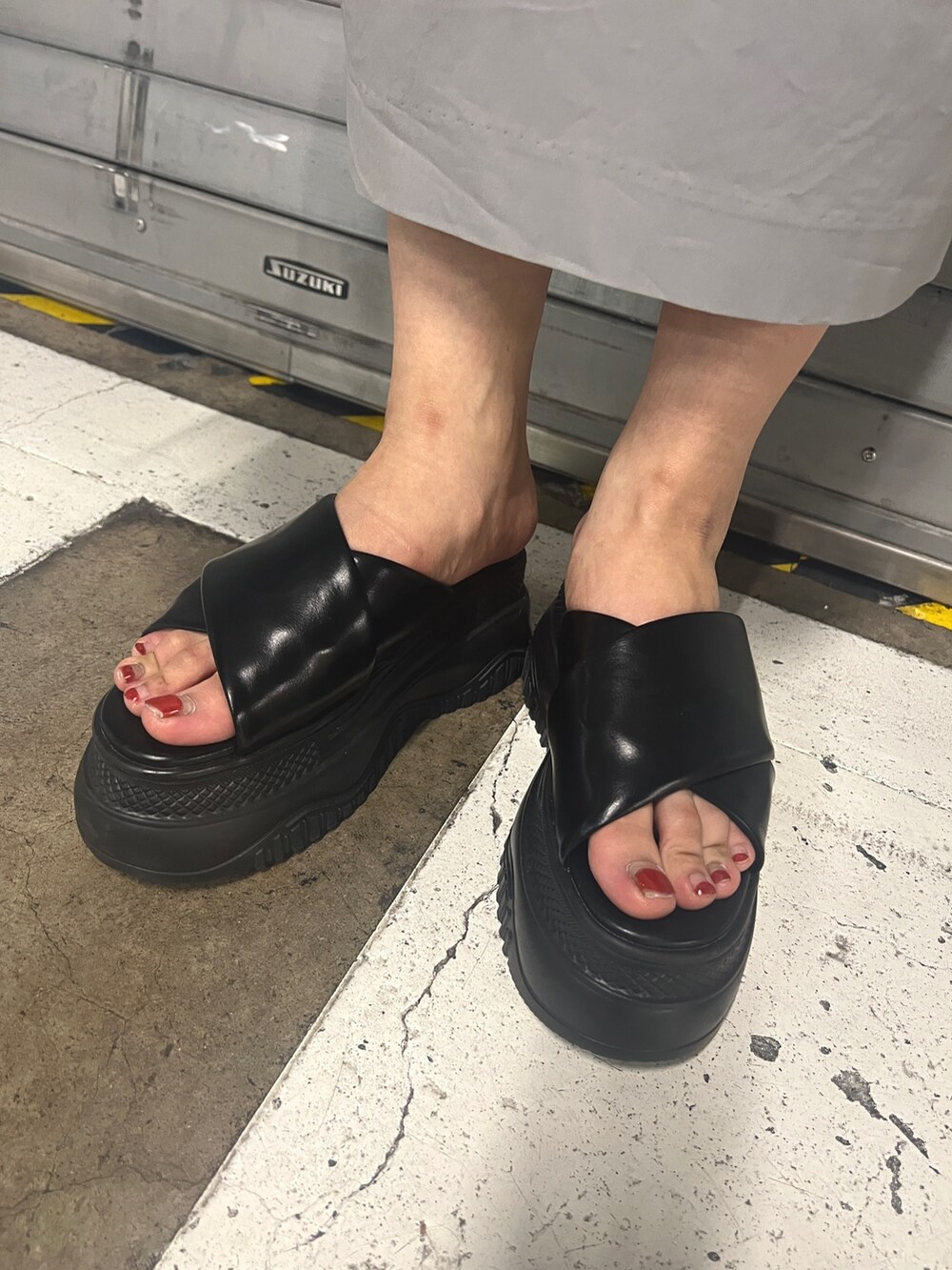 グレー系のワンピース、ホワイト系のハンドバッグ、ブラック系のサンダルを着用したレディースの夏コーディネートの4枚目の写真