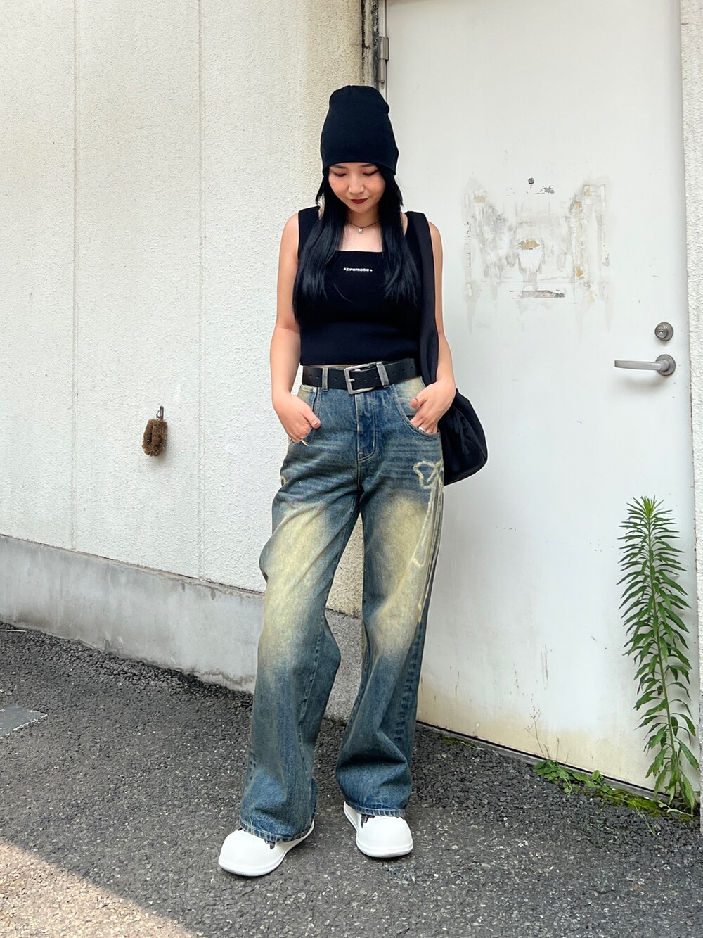 ブラック系のTシャツ/カットソー、ブルー系のデニムパンツ、ブラック系のショルダーバッグを着用したレディースの夏コーディネートの2枚目の写真