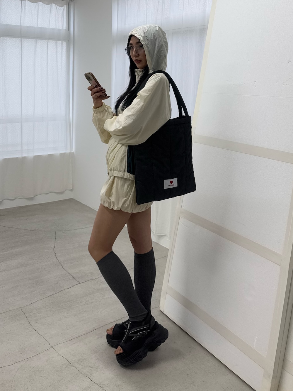 ホワイト系のブルゾン、ホワイト系のスカート、ブラック系のサンダルを着用したレディースの冬コーディネートの2枚目の写真