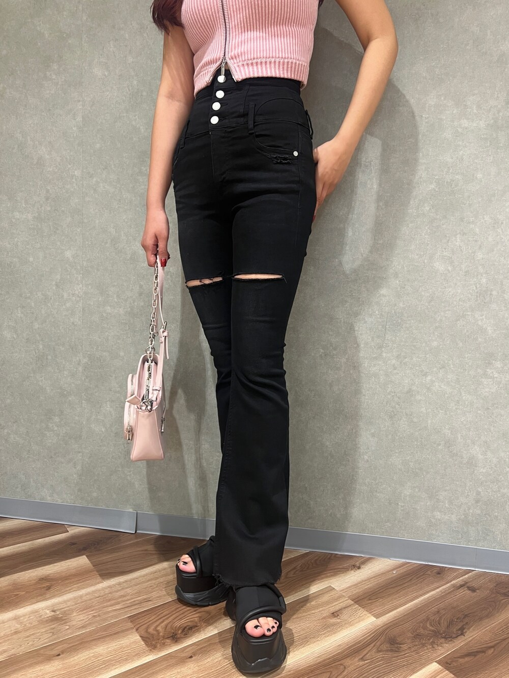 ピンク系のニット/セーター、ブラック系のデニムパンツ、ブラック系のサンダルを着用したレディースの春コーディネートの6枚目の写真