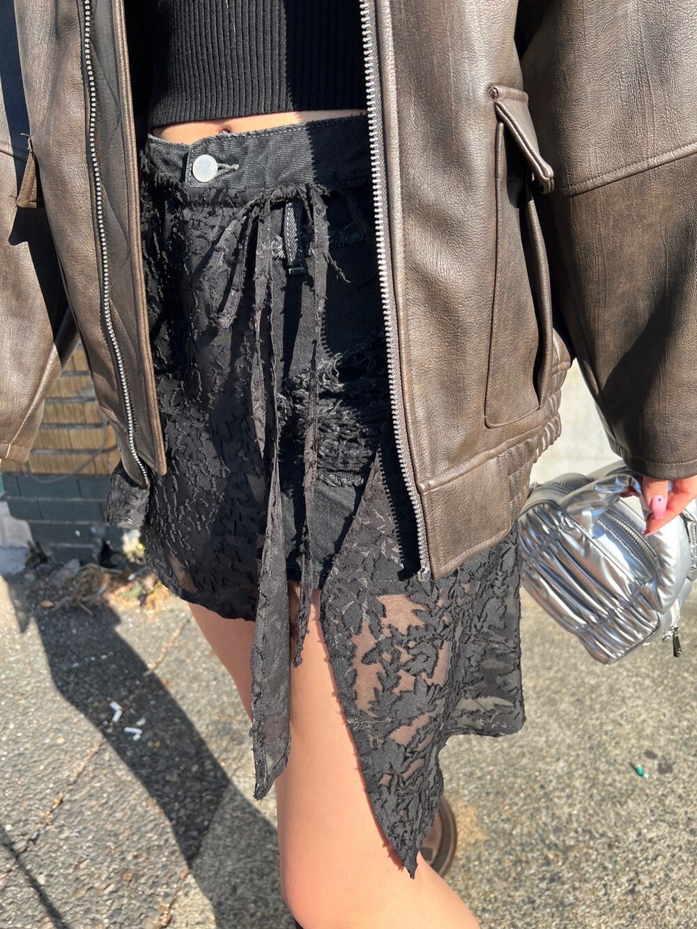 ブラウン系のブルゾン、ブラック系のニット/セーター、ブラック系のスカートを着用したレディースの冬コーディネートの6枚目の写真