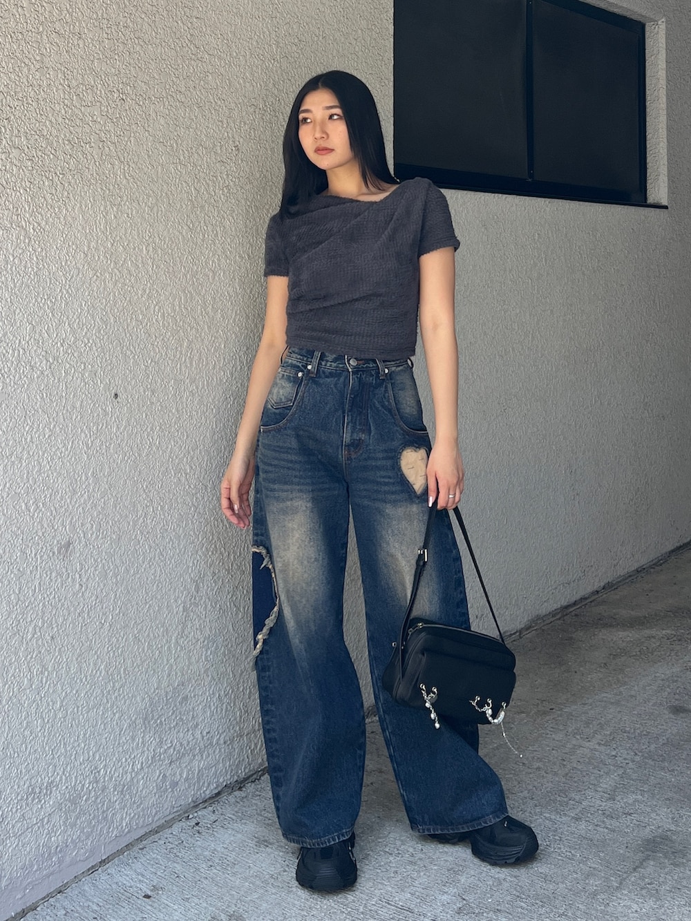 グレー系のTシャツ/カットソー、ブルー系のデニムパンツ、ブラック系のスニーカーを着用したレディースの夏コーディネートの3枚目の写真