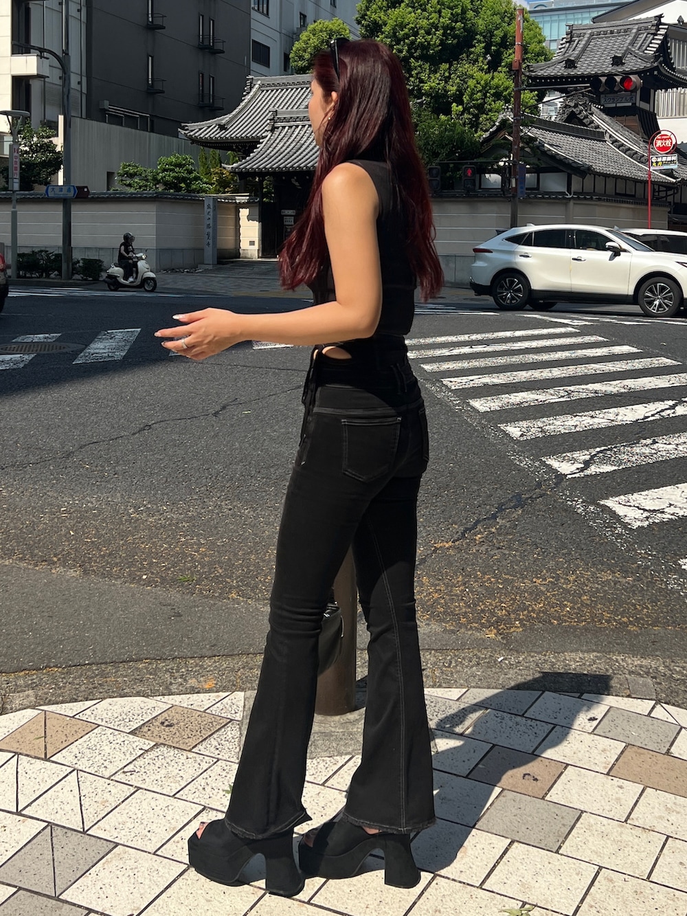 ブラック系のタンクトップ、ブラック系のデニムパンツ、ブラック系のサンダルを着用したレディースの夏コーディネートの2枚目の写真