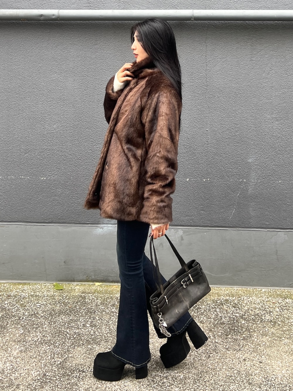 ブラウン系のその他アウター、ホワイト系のニット/セーター、ブルー系のデニムパンツを着用したレディースの秋コーディネートの2枚目の写真