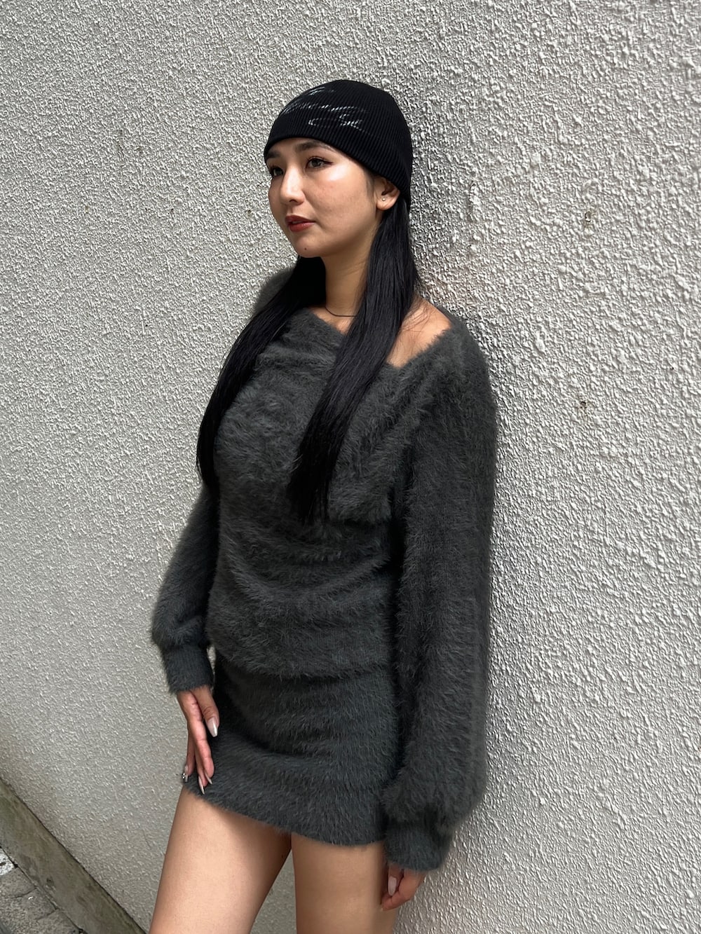 グレー系のワンピース、ブラック系のブーツ、ブラック系のニットキャップ/ビーニーを着用したレディースの冬コーディネートの3枚目の写真