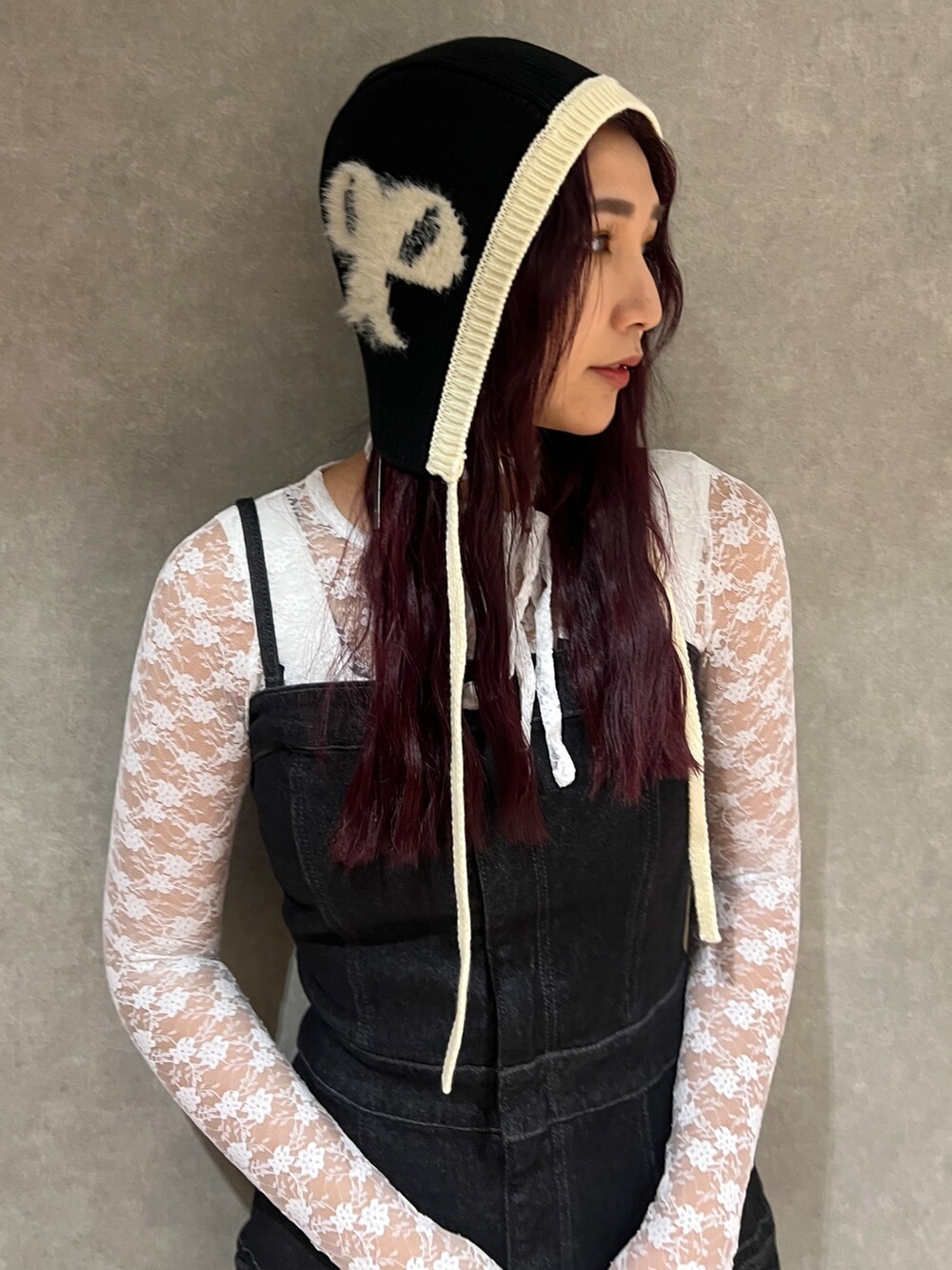 ブラック系のワンピース、ホワイト系のTシャツ/カットソー、ブラック系のブーツを着用したレディースの秋コーディネートの4枚目の写真