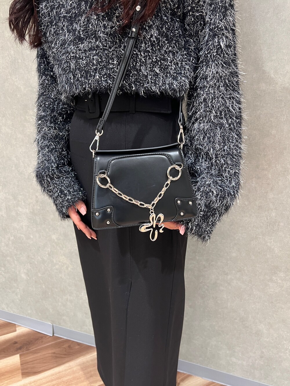 ブラック系のニット/セーター、ブラック系のスカート、ブラック系のブーツを着用したレディースの冬コーディネートの6枚目の写真