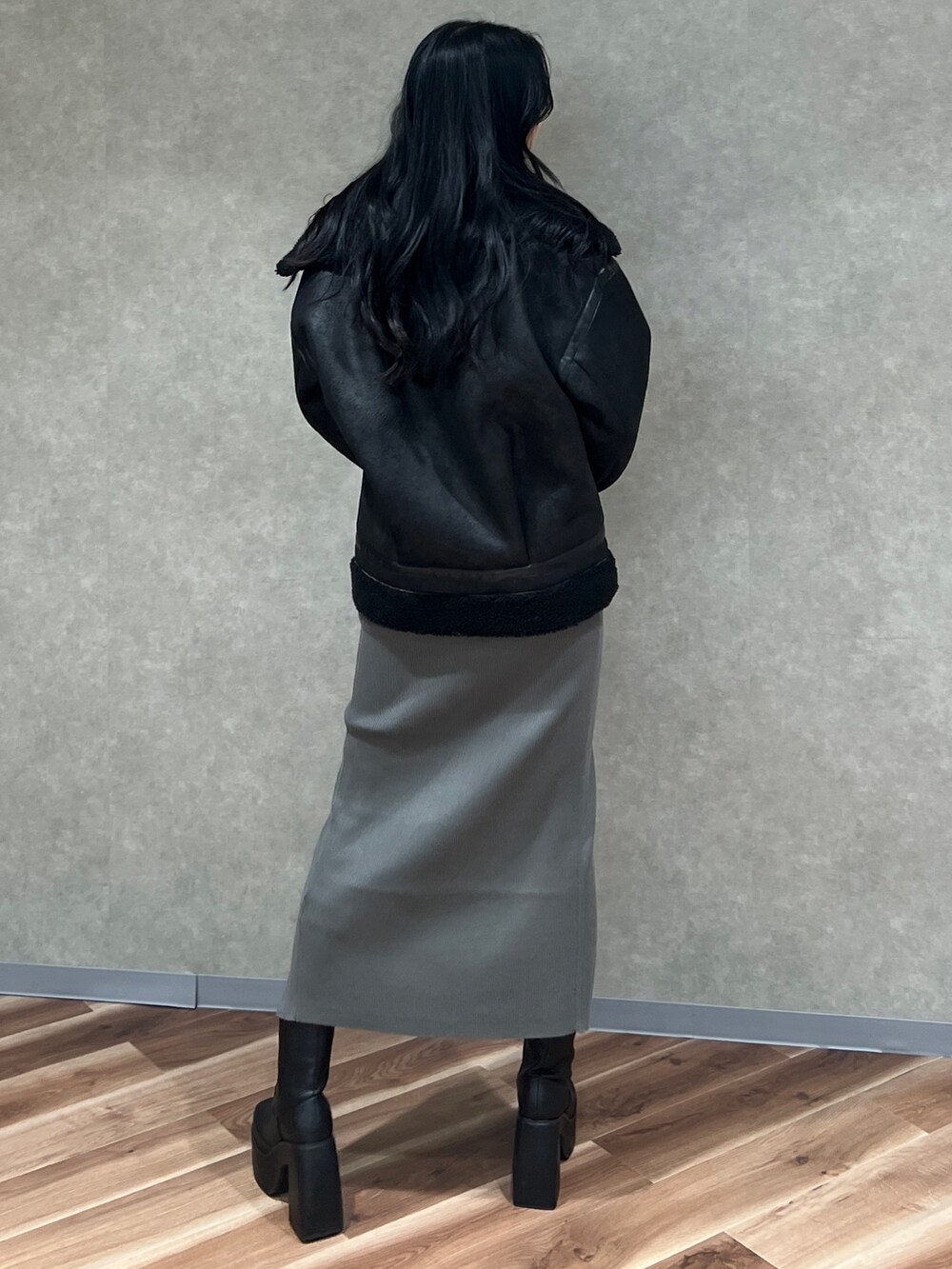 ブラック系のムートンコート、グレー系のワンピース、グレー系のハンドバッグを着用したレディースの秋コーディネートの3枚目の写真