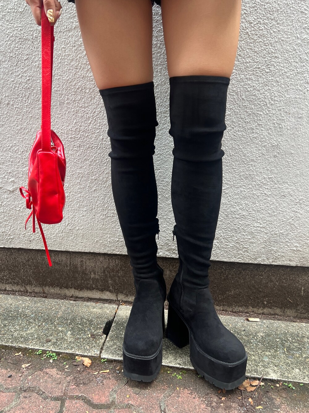 ブラック系のニット/セーター、ブラック系のその他パンツ、ブラック系のブーツを着用したレディースの秋コーディネートの7枚目の写真