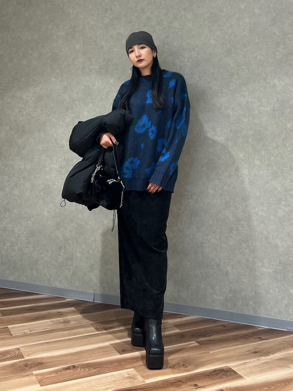 ブルー系のニット/セーター、ブラック系のブルゾン、ブラック系のスカートを着用したレディースの秋コーディネートの9枚目の写真