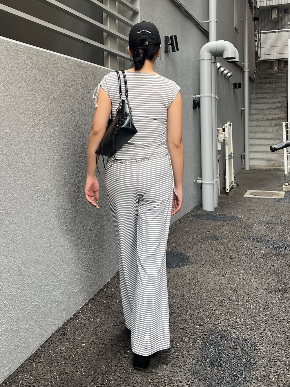 ホワイト系のTシャツ/カットソー、ホワイト系のその他パンツ、ブラック系のショルダーバッグを着用したレディースの春コーディネートの2枚目の写真