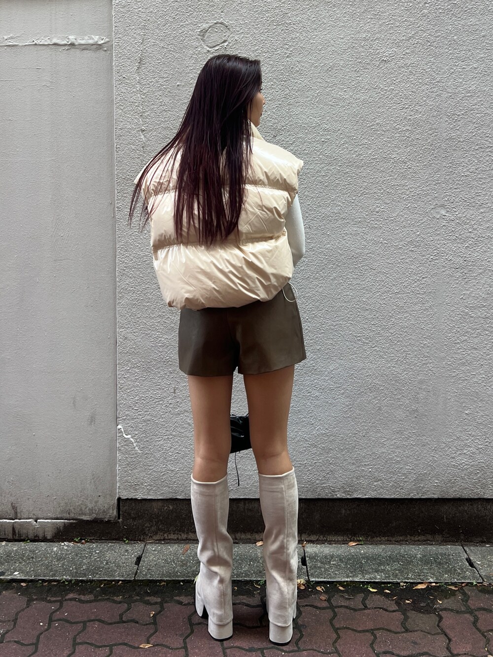 ホワイト系のダウンベスト、ホワイト系のニット/セーター、ブラウン系のその他パンツを着用したレディースの秋コーディネートの3枚目の写真