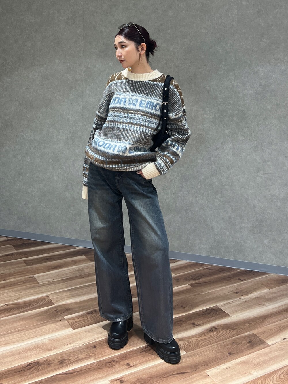 ベージュ系のニット/セーター、ブルー系のデニムパンツ、ブラック系のブーツを着用したレディースの冬コーディネートの2枚目の写真