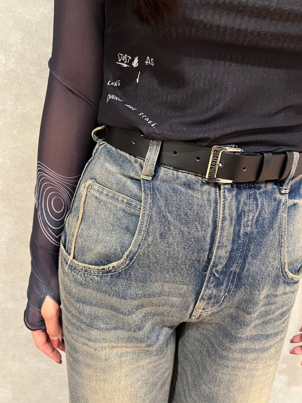 ブラック系のTシャツ/カットソー、ブルー系のデニムパンツ、ブラック系のブーツを着用したレディースの秋コーディネートの7枚目の写真