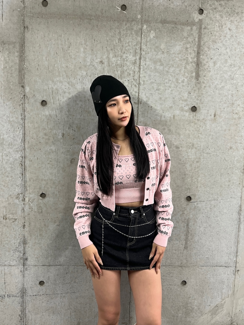 ピンク系のニット/セーター、ブルー系のスカート、ブラック系のブーツを着用したレディースの秋コーディネートの2枚目の写真