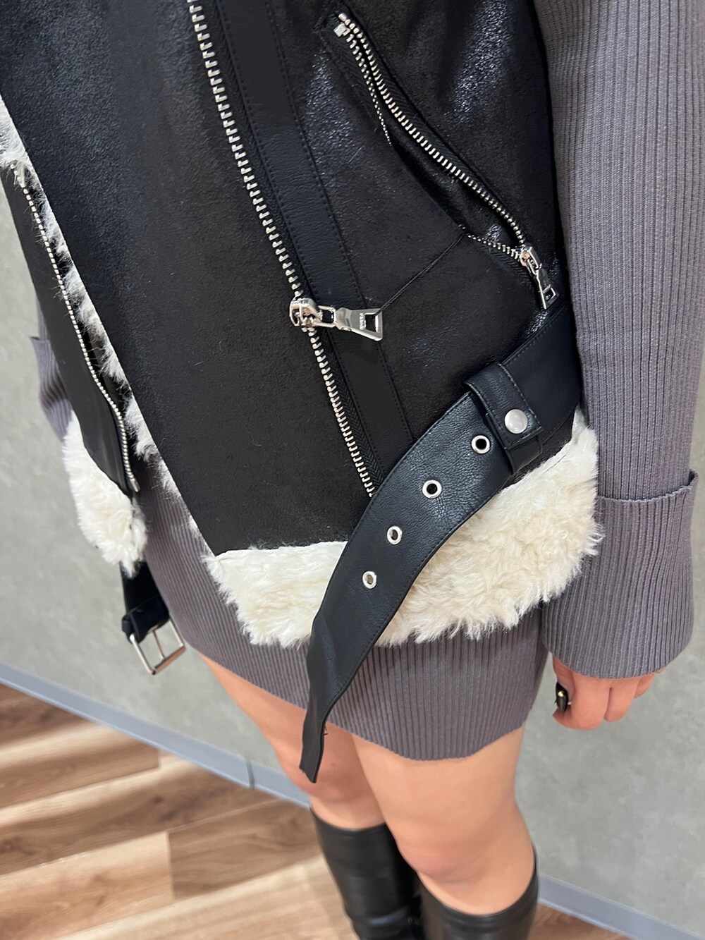 ブラック系のムートンコート、ブラック系のブーツ、グレー系のワンピースを着用したレディースの秋コーディネートの5枚目の写真