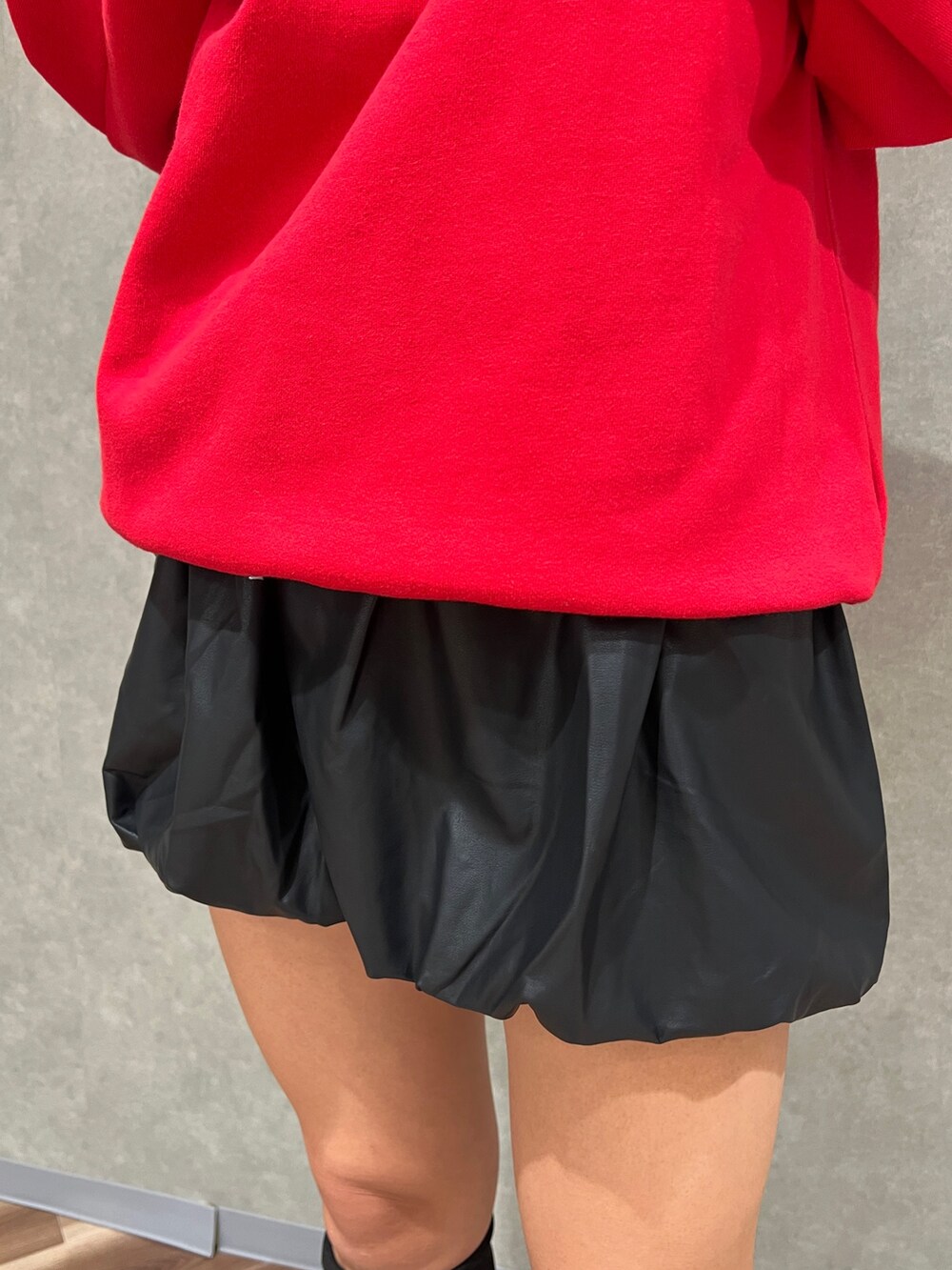 レッド系のスウェット、ブラック系のハンドバッグ、ブラック系のブーツを着用したレディースの秋コーディネートの5枚目の写真