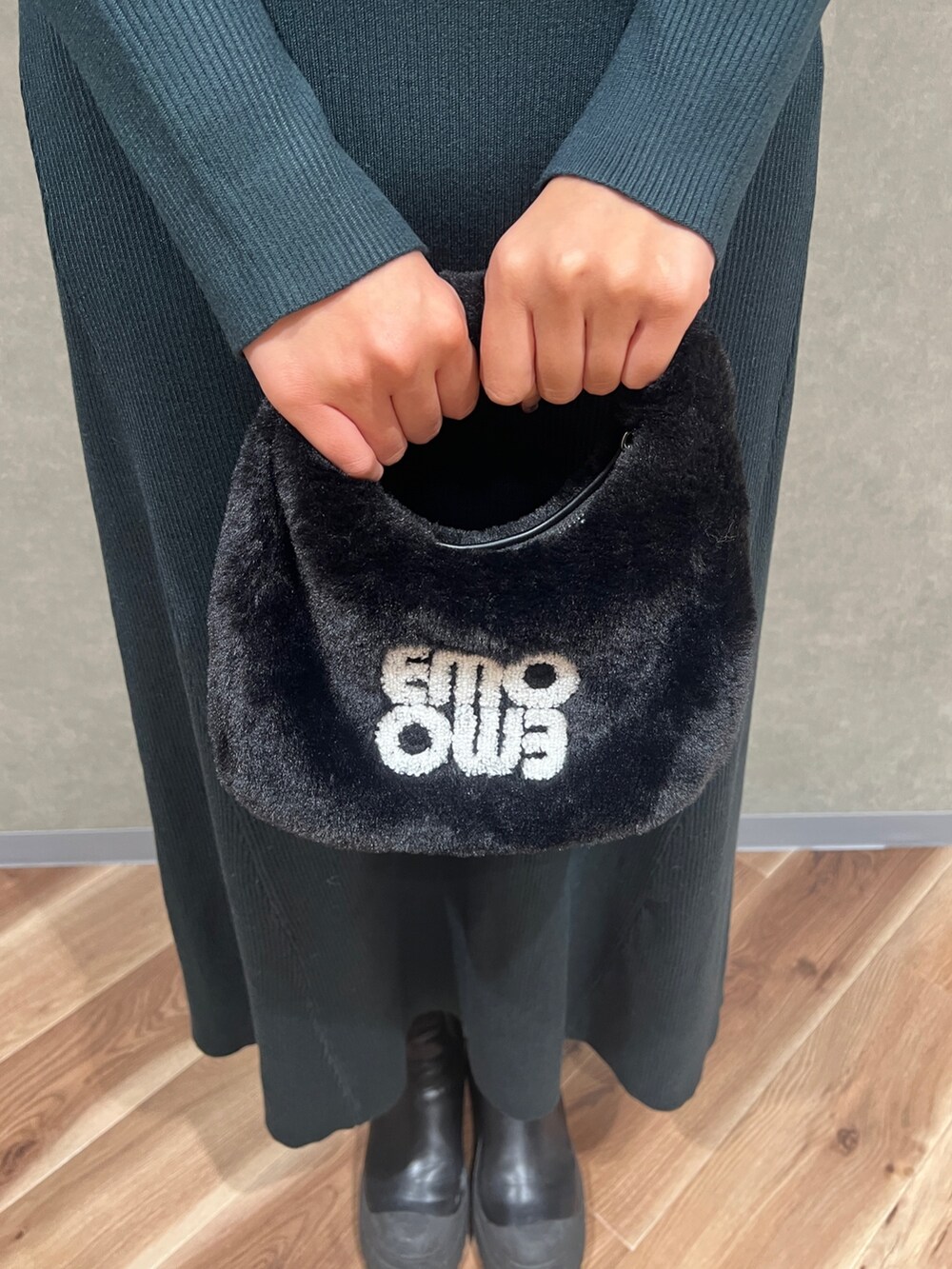 グリーン系のワンピース、ホワイト系のチェスターコート、ブラック系のハンドバッグを着用したレディースの冬コーディネートの6枚目の写真