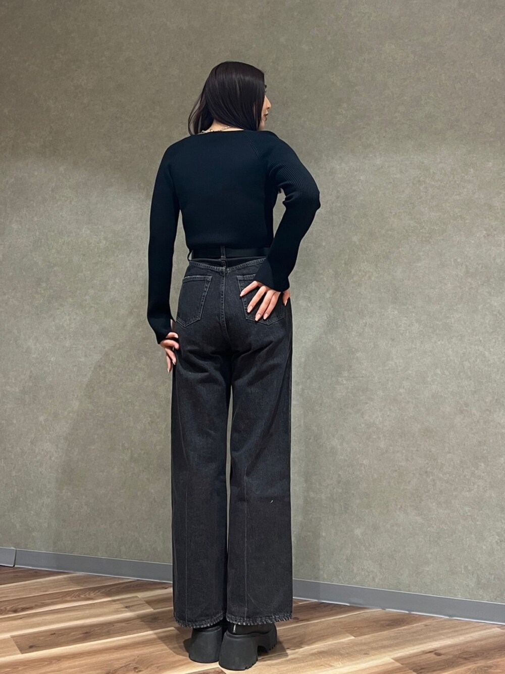 ブラック系のニット/セーター、ブラック系のデニムパンツ、ブラック系のブーツを着用したレディースの冬コーディネートの3枚目の写真
