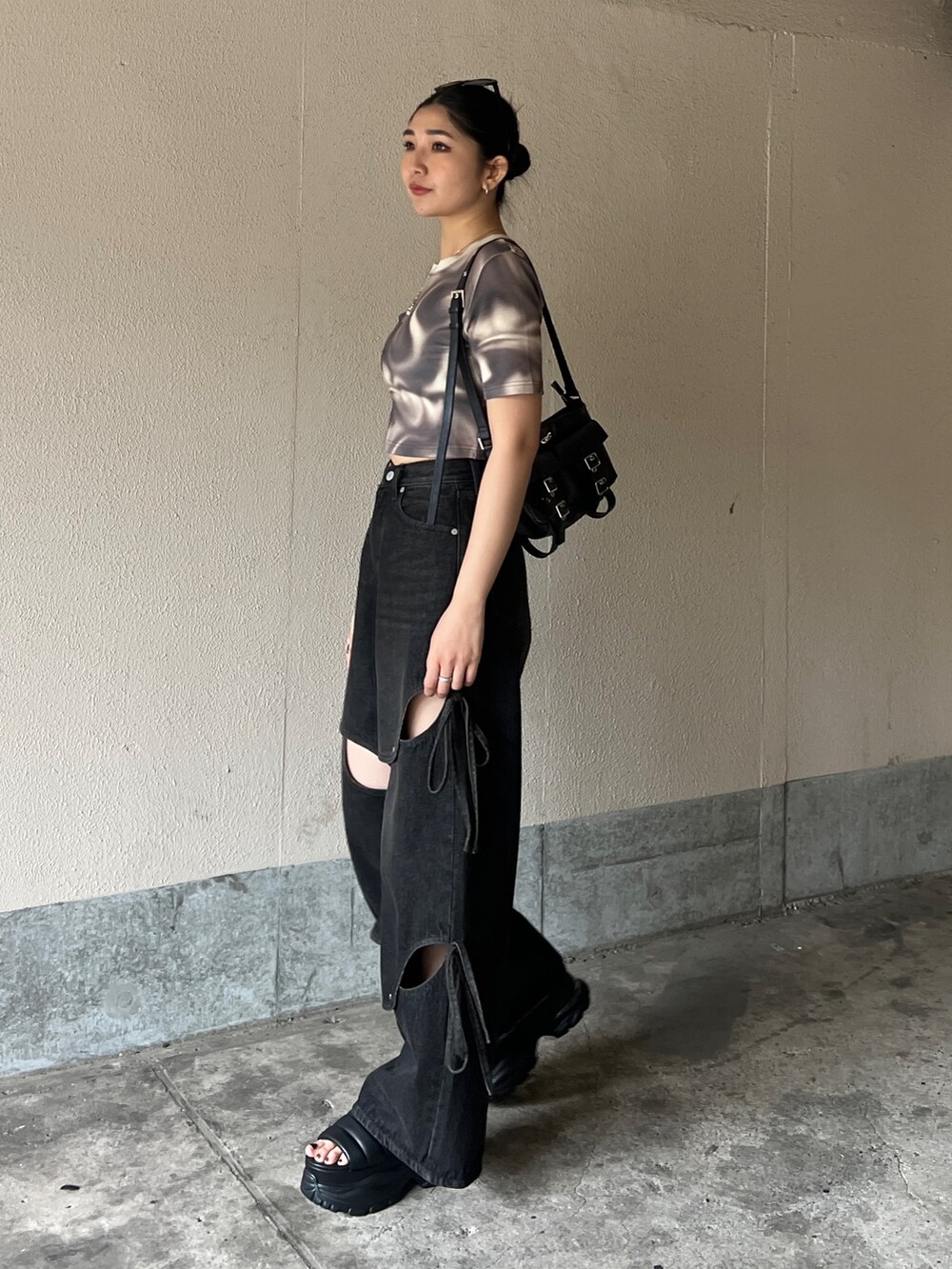 ベージュ系のTシャツ/カットソー、ブラック系のデニムパンツ、ブラック系のサンダルを着用したレディースの春コーディネートの2枚目の写真