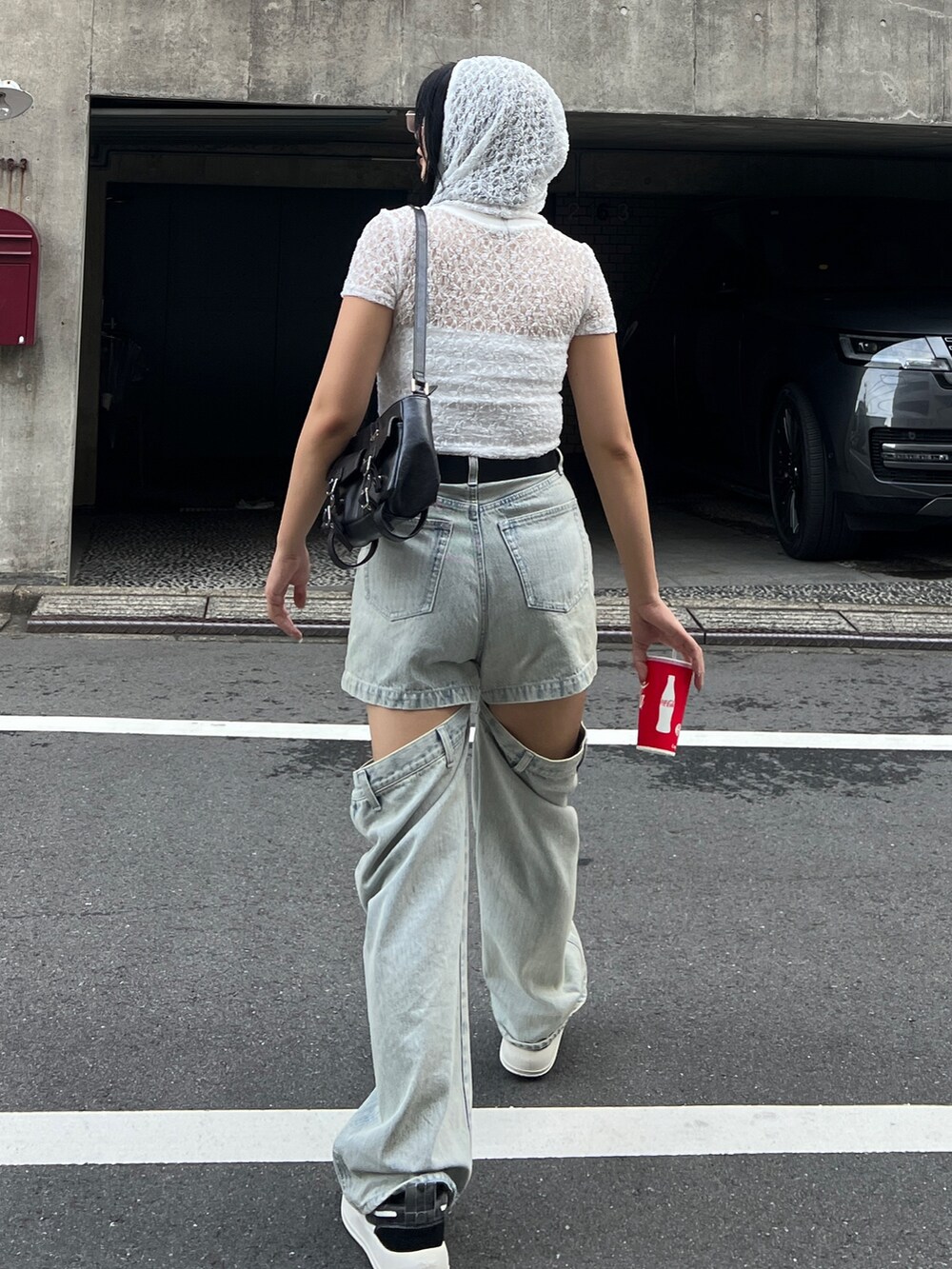 ホワイト系のTシャツ/カットソー、ブルー系のデニムパンツ、ブラック系のハンドバッグを着用したレディースの夏コーディネートの3枚目の写真