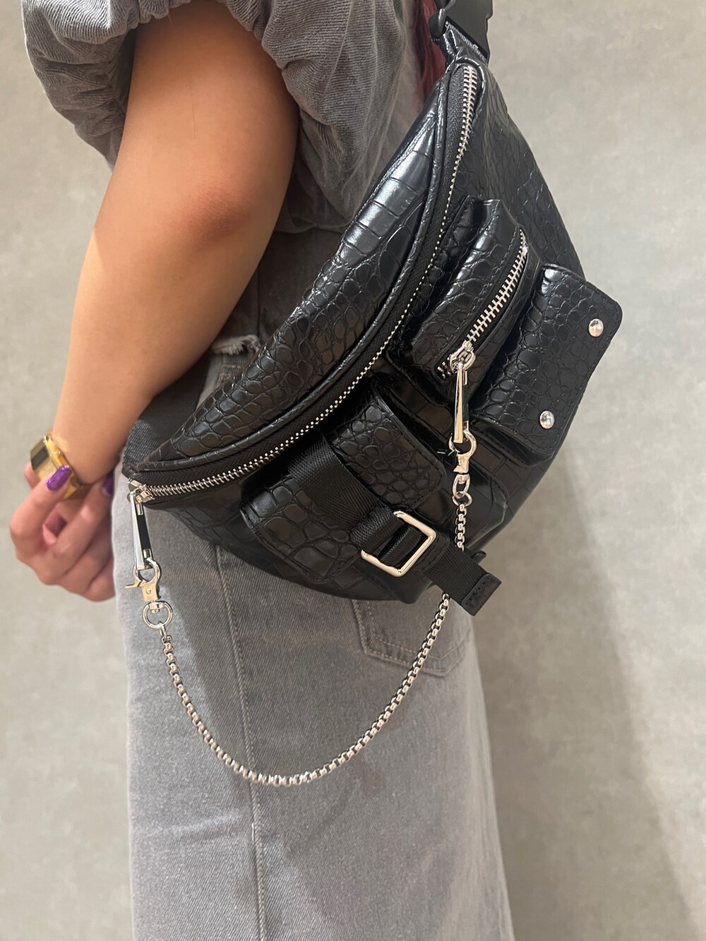 ブラック系のサンダル、グレー系のスカート、ブラック系のハンドバッグを着用したレディースの春コーディネートの5枚目の写真