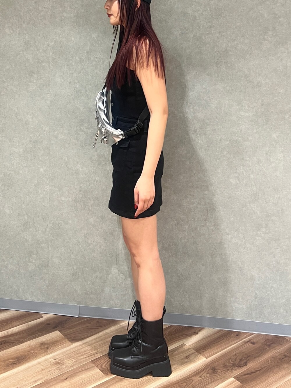 ブラック系のワンピース、ブラック系のブーツ、シルバー系のハンドバッグを着用したレディースの春コーディネートの3枚目の写真