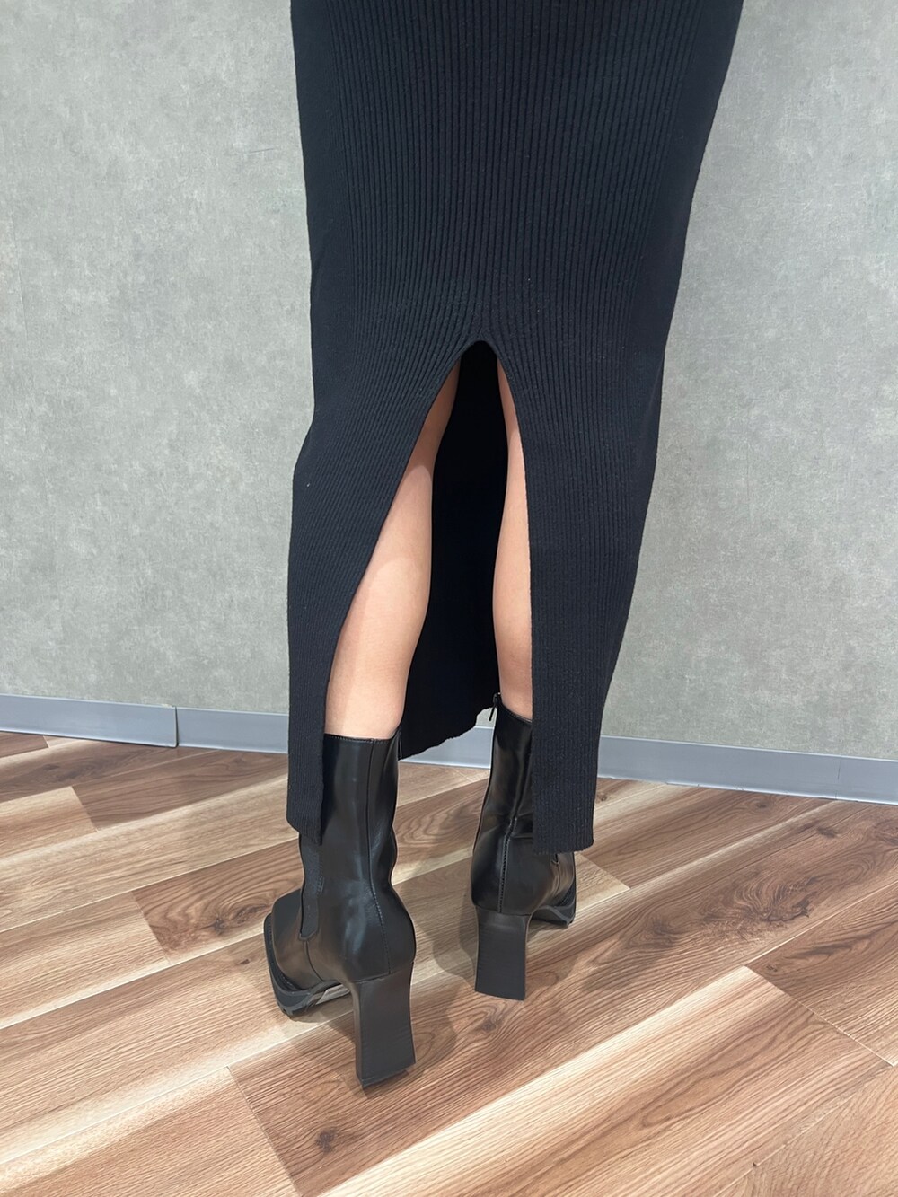 ブラック系のワンピース、ブラック系のハンドバッグ、ブラック系のブーツを着用したレディースの秋コーディネートの4枚目の写真