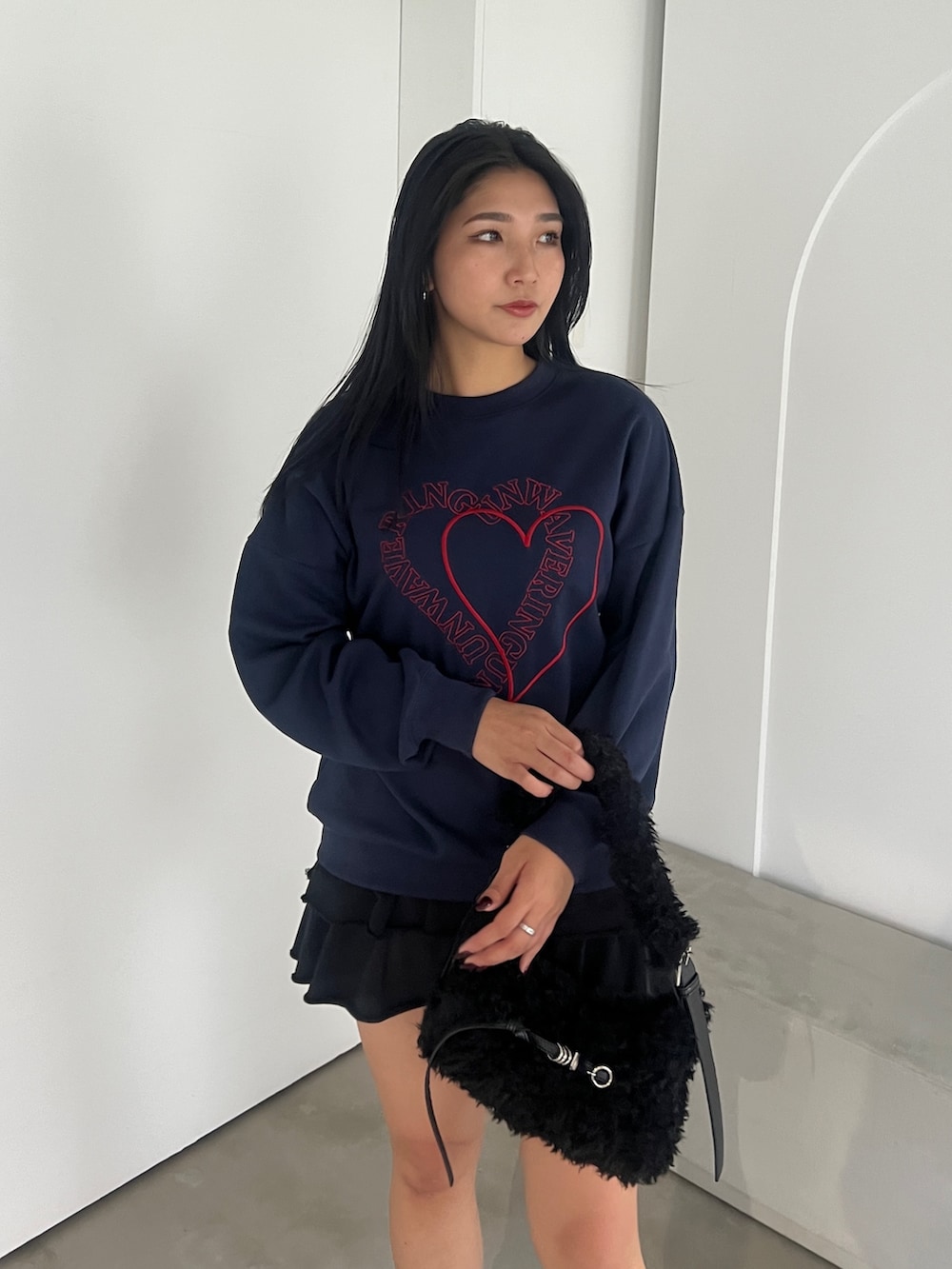 ブルー系のスウェット、ブラック系のスカート、ブラック系のブーツを着用したレディースの秋コーディネートの4枚目の写真