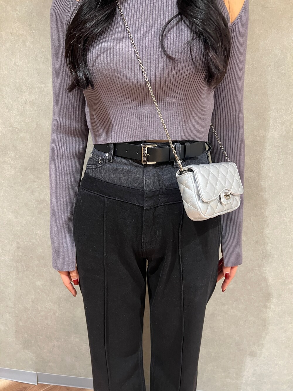 グレー系のニット/セーター、ブラック系のデニムパンツ、ブラック系のブーツを着用したレディースの冬コーディネートの4枚目の写真