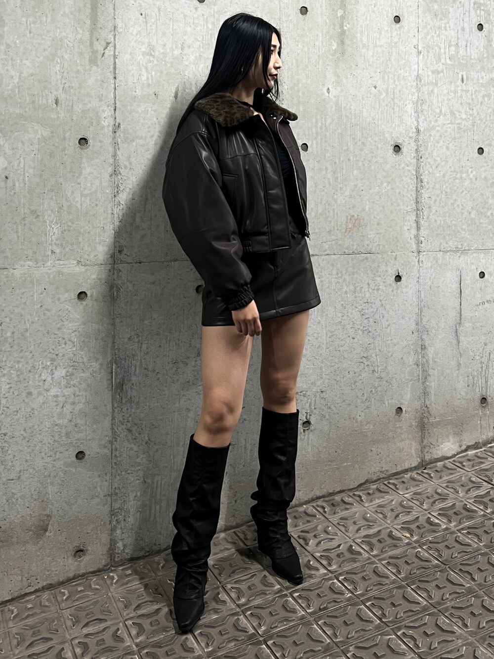 ブラック系のブルゾン、ブラウン系のスカート、ブラック系のブーツを着用したレディースの秋コーディネートの2枚目の写真