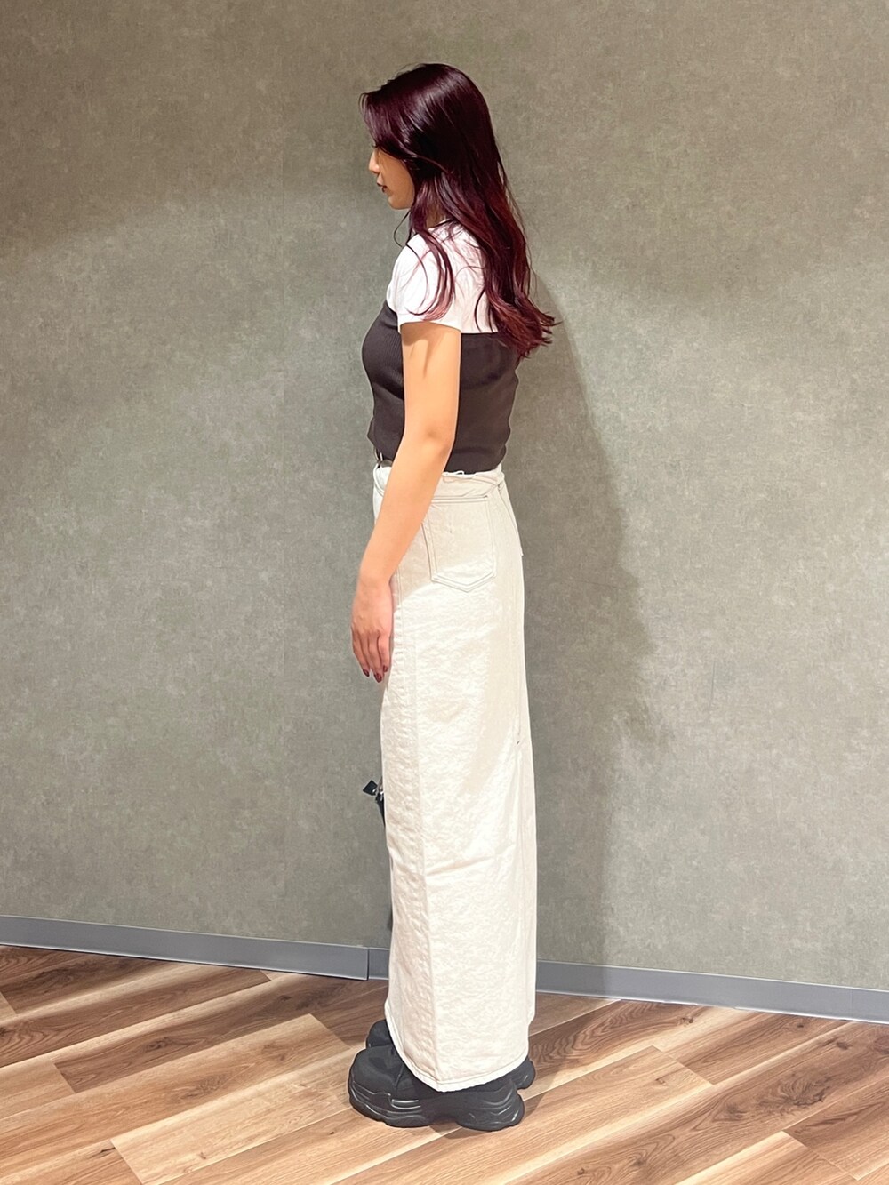 ブラウン系のチューブトップ、ホワイト系のTシャツ/カットソー、ブラック系のショルダーバッグを着用したレディースの春コーディネートの3枚目の写真