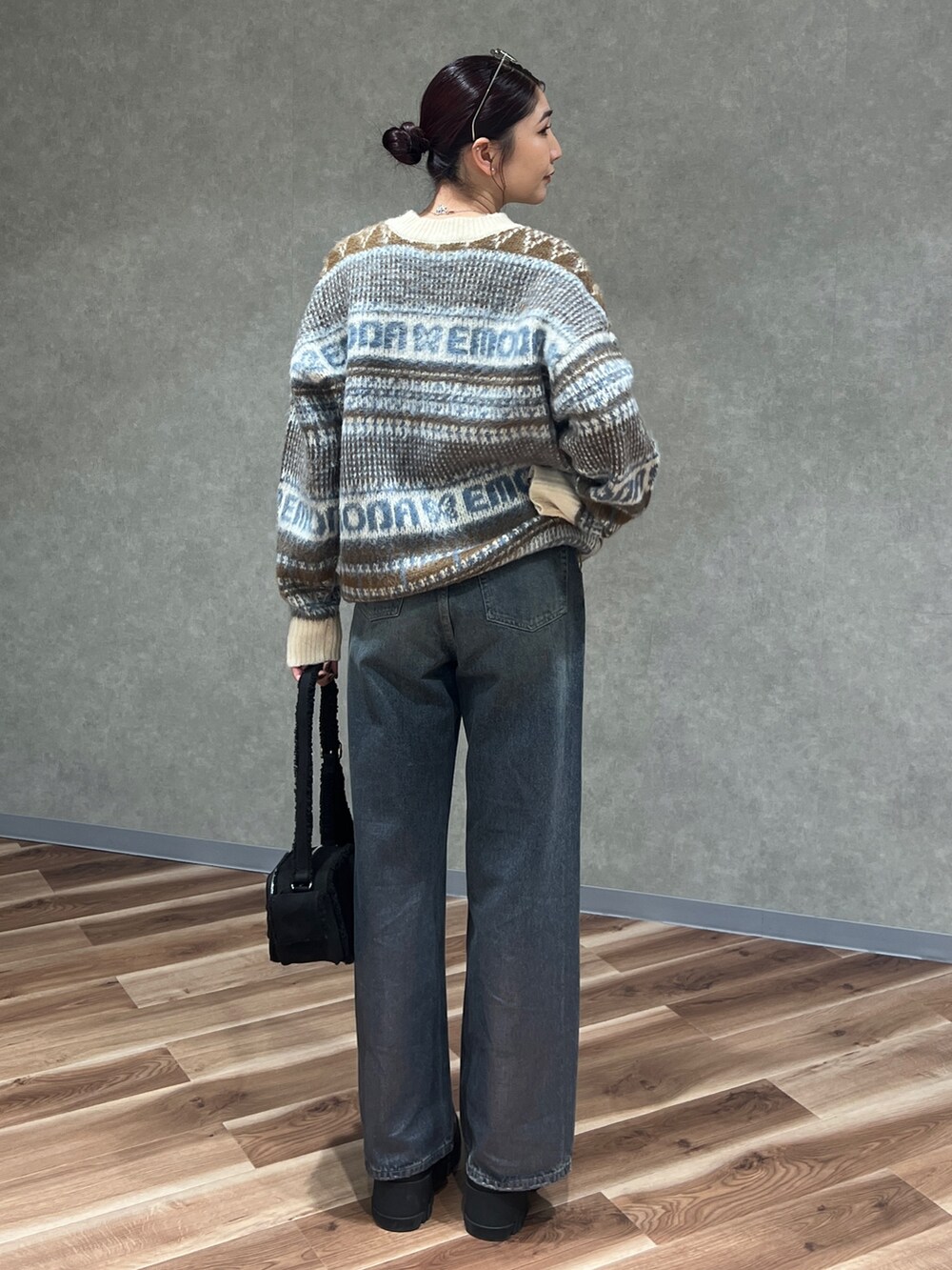 ベージュ系のニット/セーター、ブルー系のデニムパンツ、ブラック系のブーツを着用したレディースの冬コーディネートの3枚目の写真