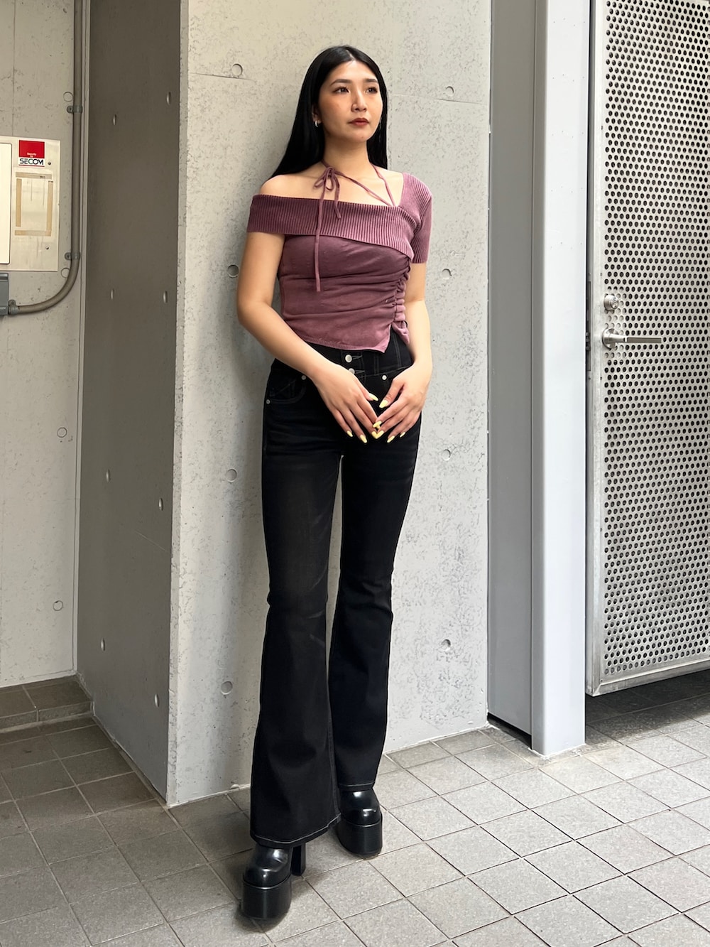 レッド系のニット/セーター、ブラック系のデニムパンツ、ブラック系のブーツを着用したレディースの夏コーディネートの2枚目の写真
