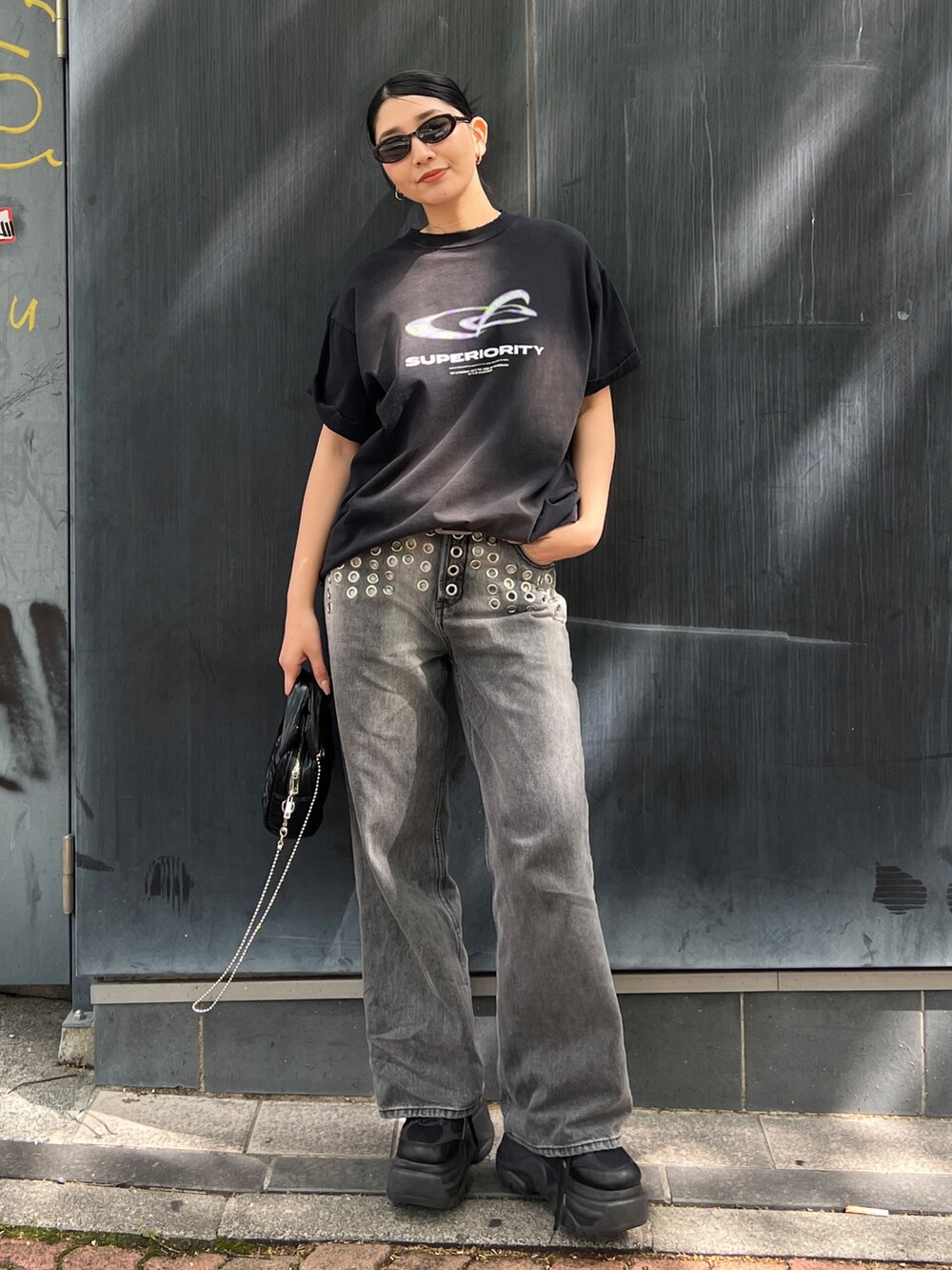ブラック系のTシャツ/カットソー、ブラック系のスニーカー、ブラック系のハンドバッグを着用したレディースの春コーディネートの3枚目の写真
