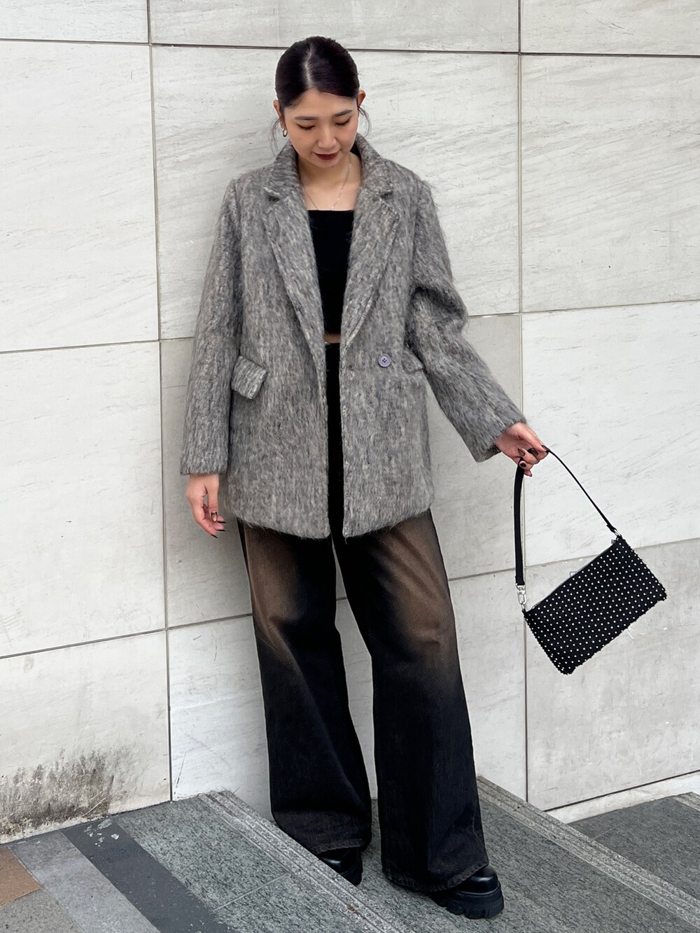 ブラック系のデニムパンツ、ブラック系のブーツ、ベージュ系のテーラードジャケットを着用したレディースの冬コーディネートの2枚目の写真