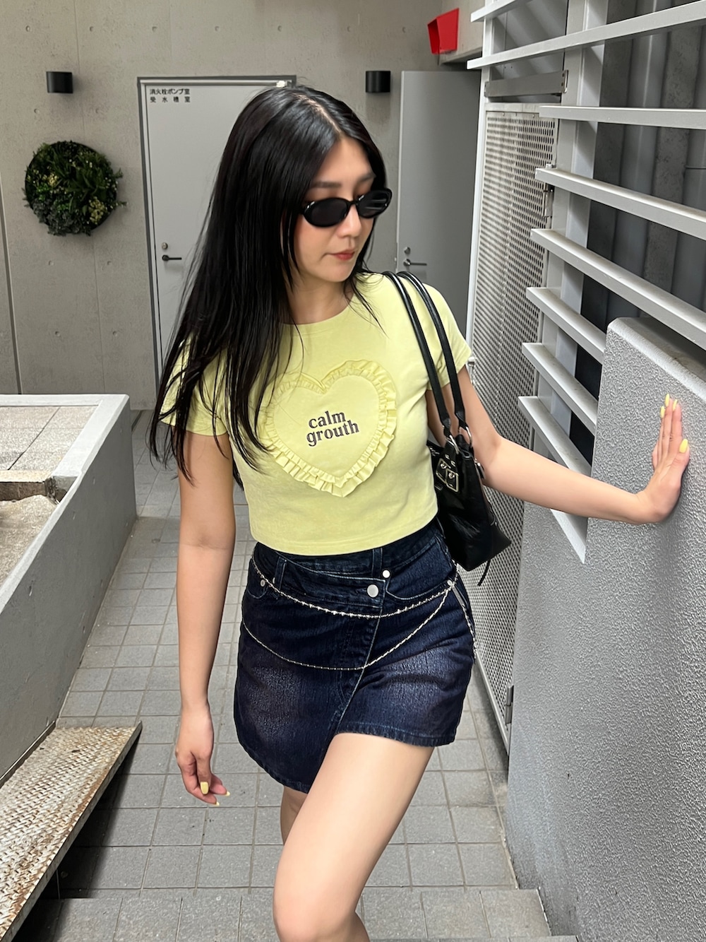 イエロー系のTシャツ/カットソー、ブルー系のスカート、ブラック系のブーツを着用したレディースの夏コーディネートの5枚目の写真