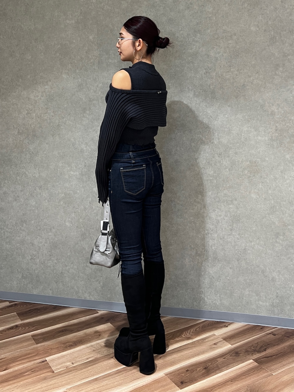 ブラック系のニット/セーター、ブルー系のデニムパンツ、その他のブーツを着用したレディースの秋コーディネートの2枚目の写真