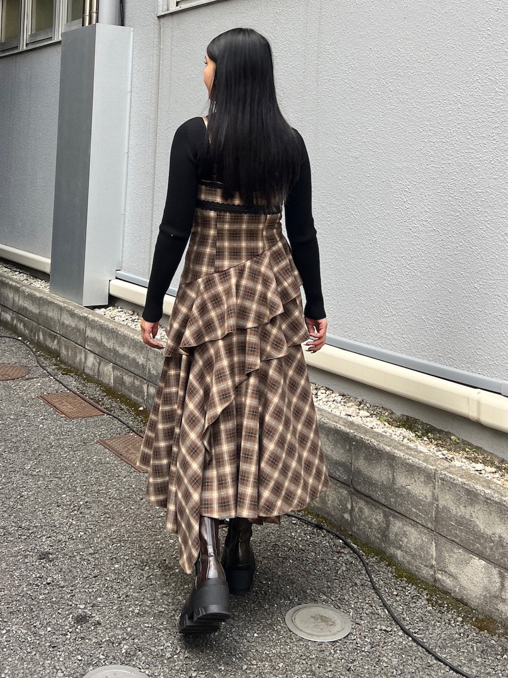 ブラック系のニット/セーター、ベージュ系のワンピース、ブラウン系のブーツを着用したレディースの冬コーディネートの3枚目の写真