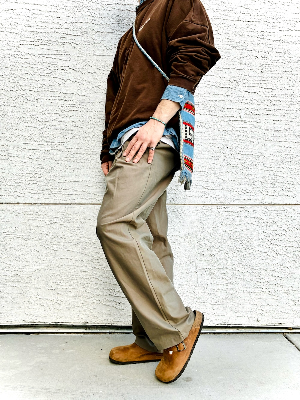 ブラウン系のスウェット、ベージュ系のスラックス、ブルー系のシャツ/ブラウスを着用したメンズの冬コーディネートの3枚目の写真