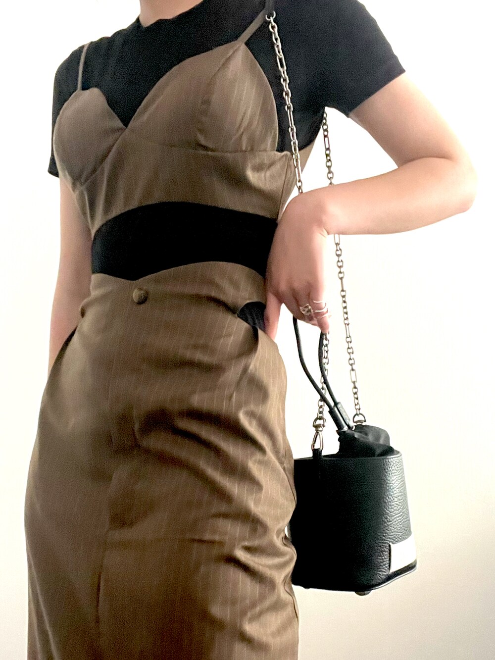 ブラック系のトップス、ベージュ系のスカート、ブラック系のショルダーバッグを着用したレディースの夏コーディネートの2枚目の写真