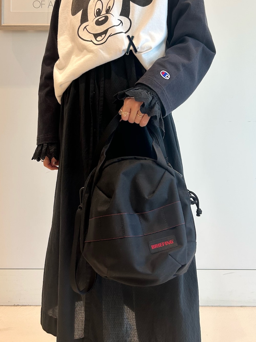 ブラック系のワンピース、ブラック系のTシャツ/カットソー、ブラック系のショルダーバッグを着用したレディースの夏コーディネートの8枚目の写真